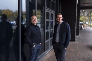 Ben Muncaster and Ant Morse stand outside glass building