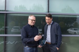 Ant Morse and Ben Muncaster look at a phone 
